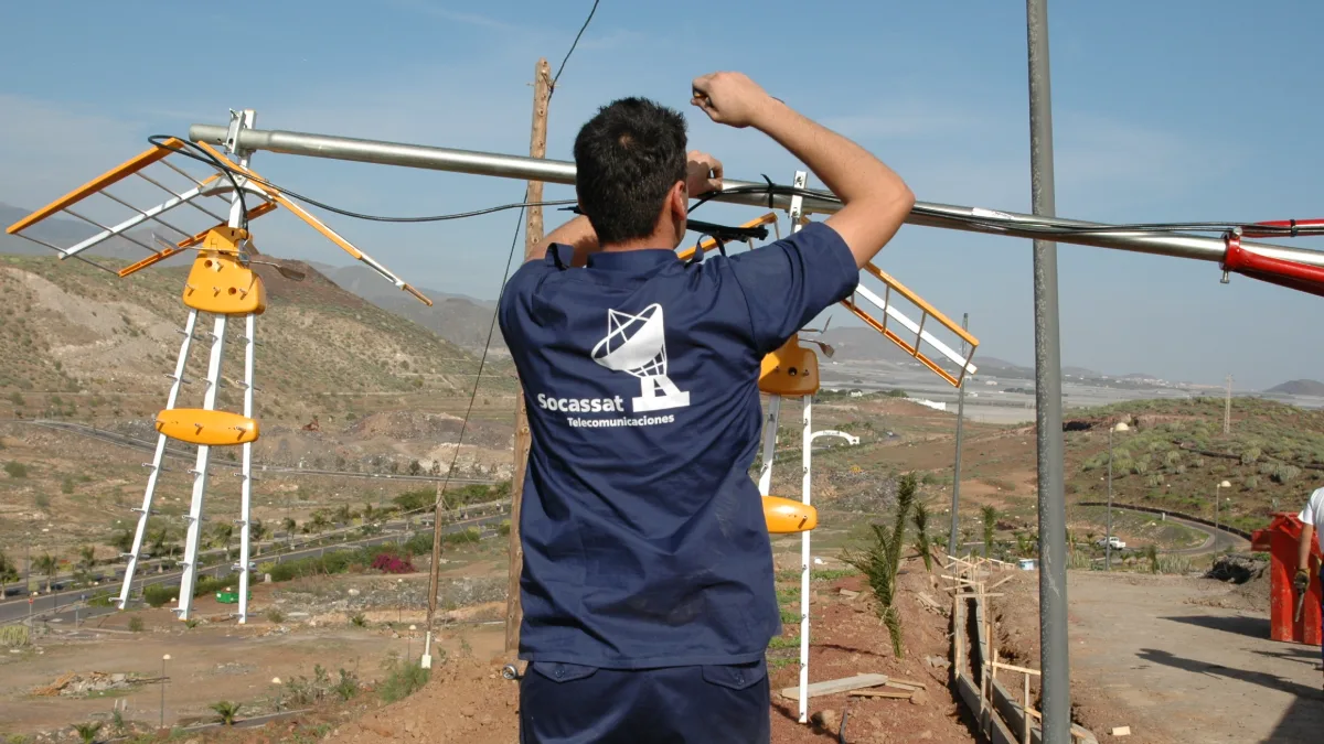 Técnico de Socassat instalando antenas de televisión en un mástil