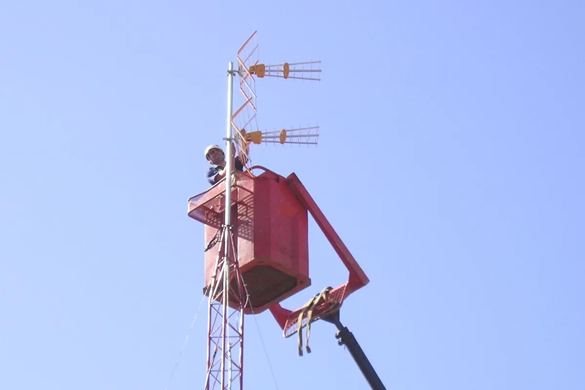 Antenista de Socassat instalando antenas TDT en un mástil desde una plataforma elevadora