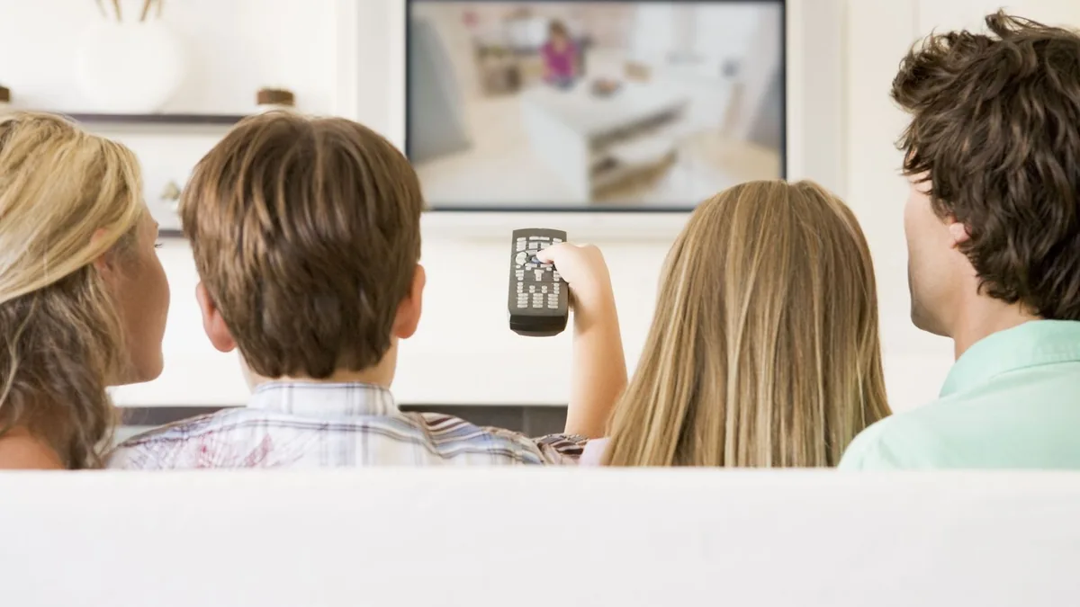 Familia viendo la televisión sin cortes después de la reparación de la antena
