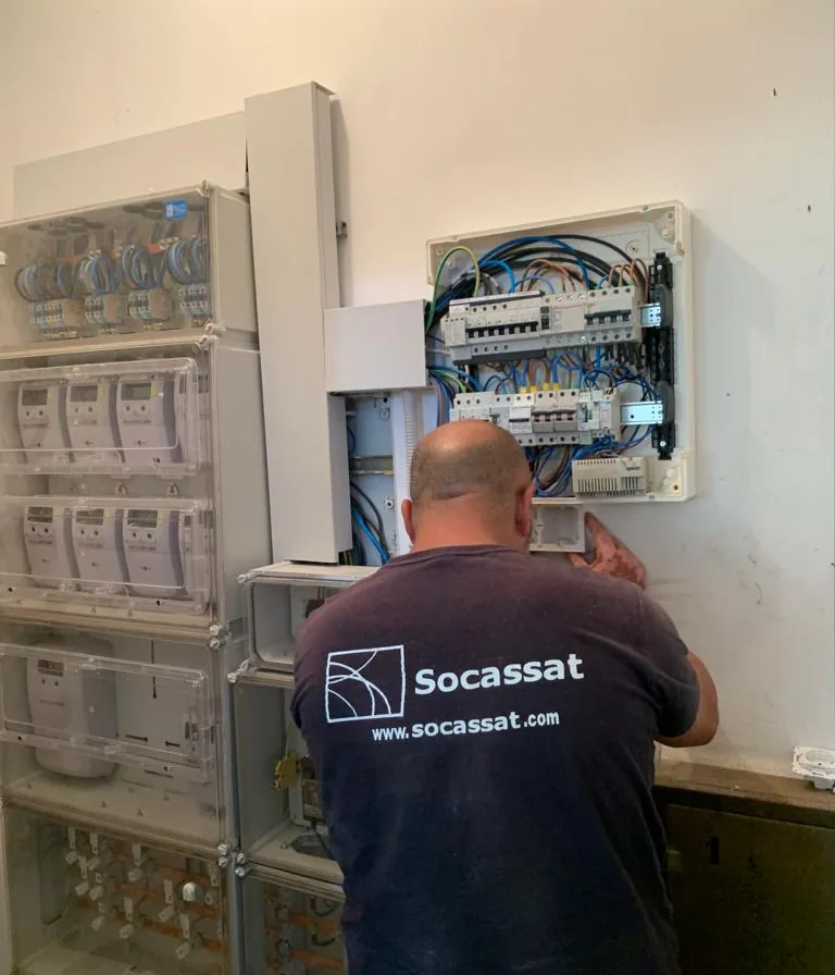 Electricista de Socassat trabajando en el cuadro de servicios comunes junto a la centralización de contadores de una comunidad