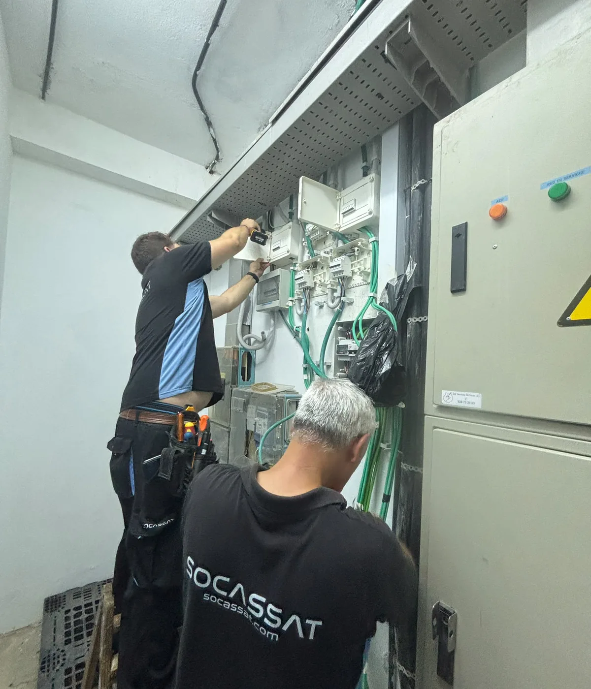 Técnicos de Socassat trabajando en el cuadro eléctrico de la sala técnica de un edificio