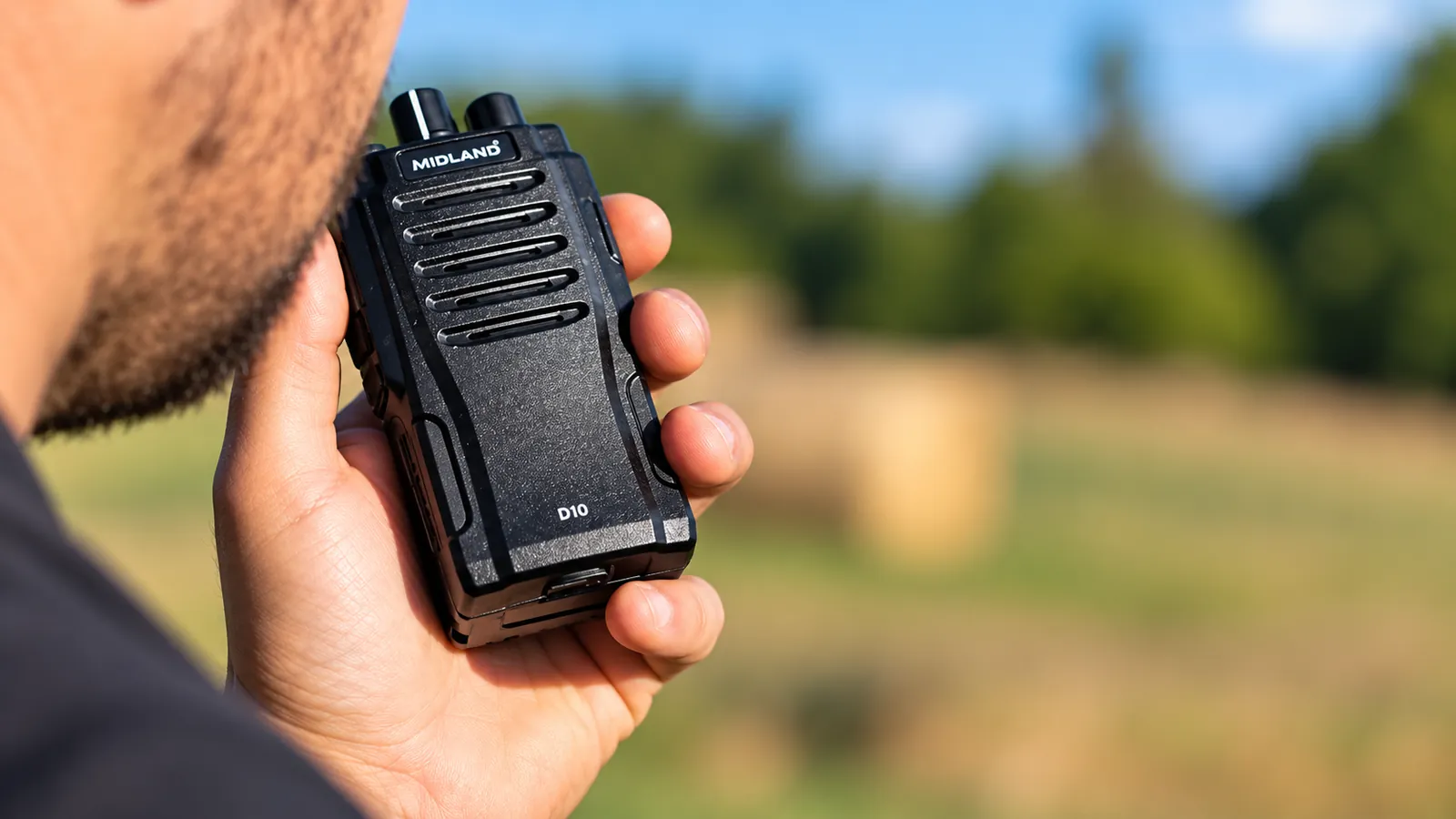 Walkie-talkie profesional Midland D10 en la mano de un usuario, al aire libre