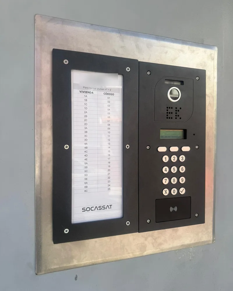 Placa de videoportero con teclado codificado instalada en la entrada de una comunidad de vecinos