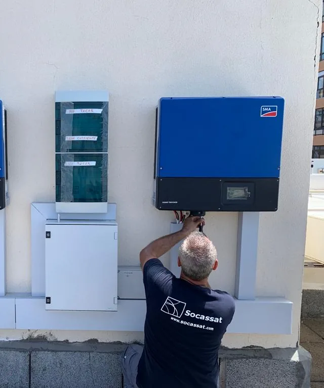 Técnico de Socassat conectando los inversores de una instalación de autoconsumo en la azotea de un edificio