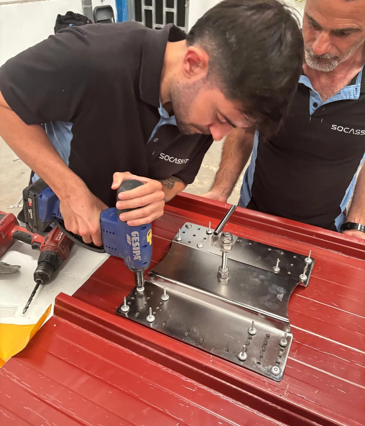 Técnico de Socassat remachando la base de una línea de vida sobre una cubierta de panel sándwich