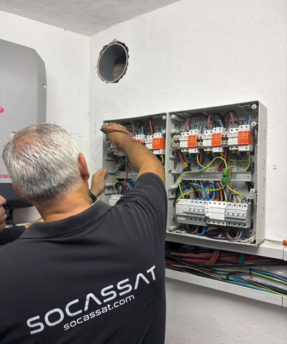 Técnico de Socassat revisando las protecciones de una instalación fotovoltaica junto al inversor
