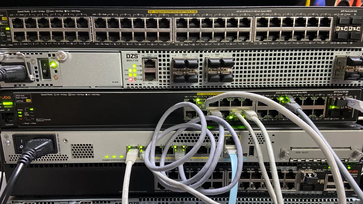 Switches Aruba PoE+ y OLT GPON DZS en el rack de comunicaciones de un hotel gestionado por Socassat