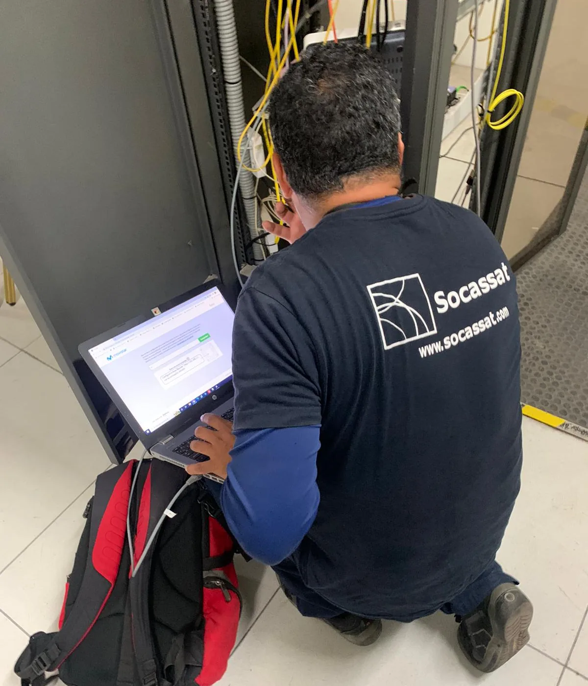 Técnico de Socassat configurando switches y router desde un portátil junto al rack de comunicaciones de un cliente
