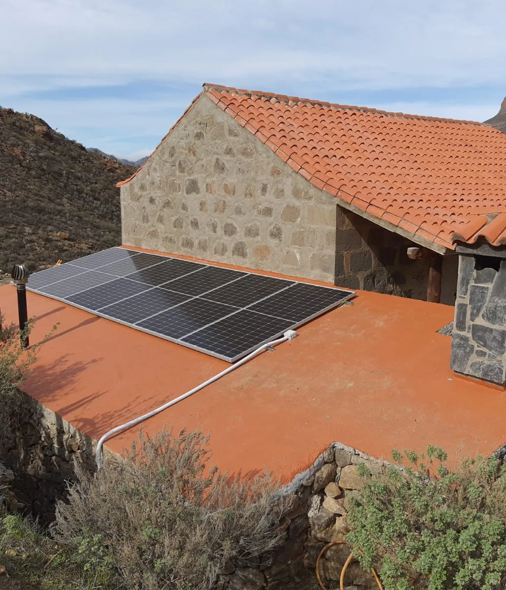 Placas solares fotovoltaicas instaladas en la azotea de una casa rural de piedra en Gran Canaria