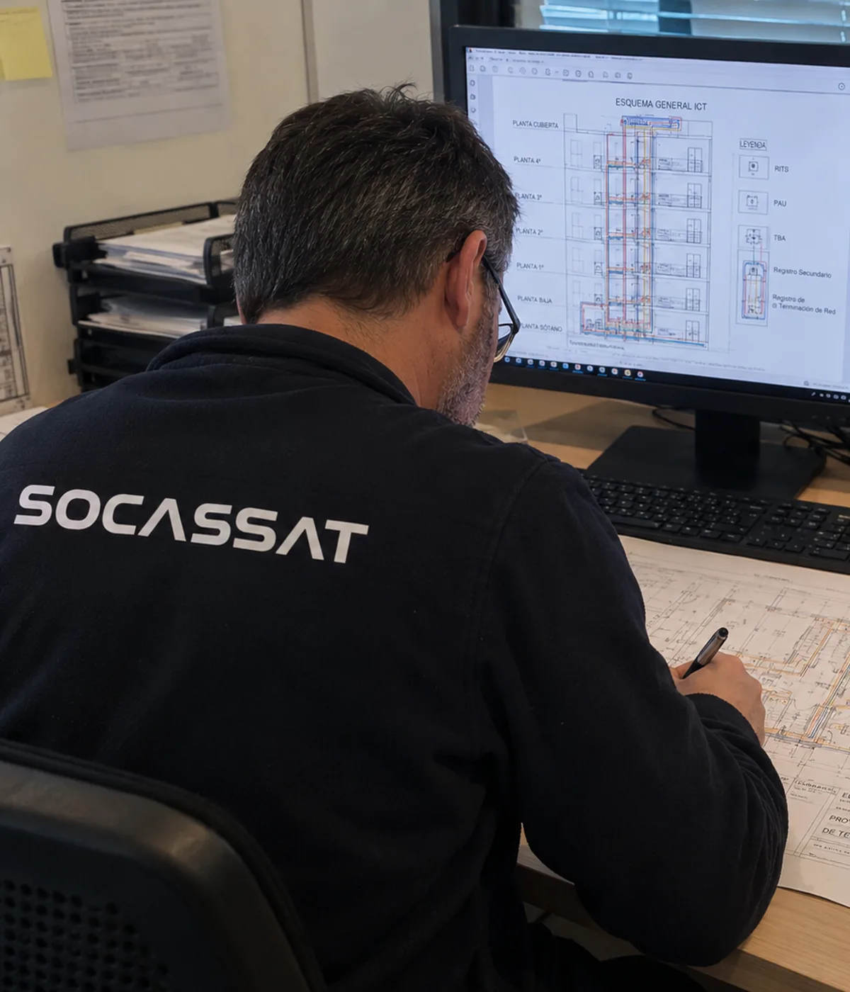 Técnico de Socassat redactando un proyecto ICT con el esquema general de la infraestructura común de telecomunicaciones de un edificio