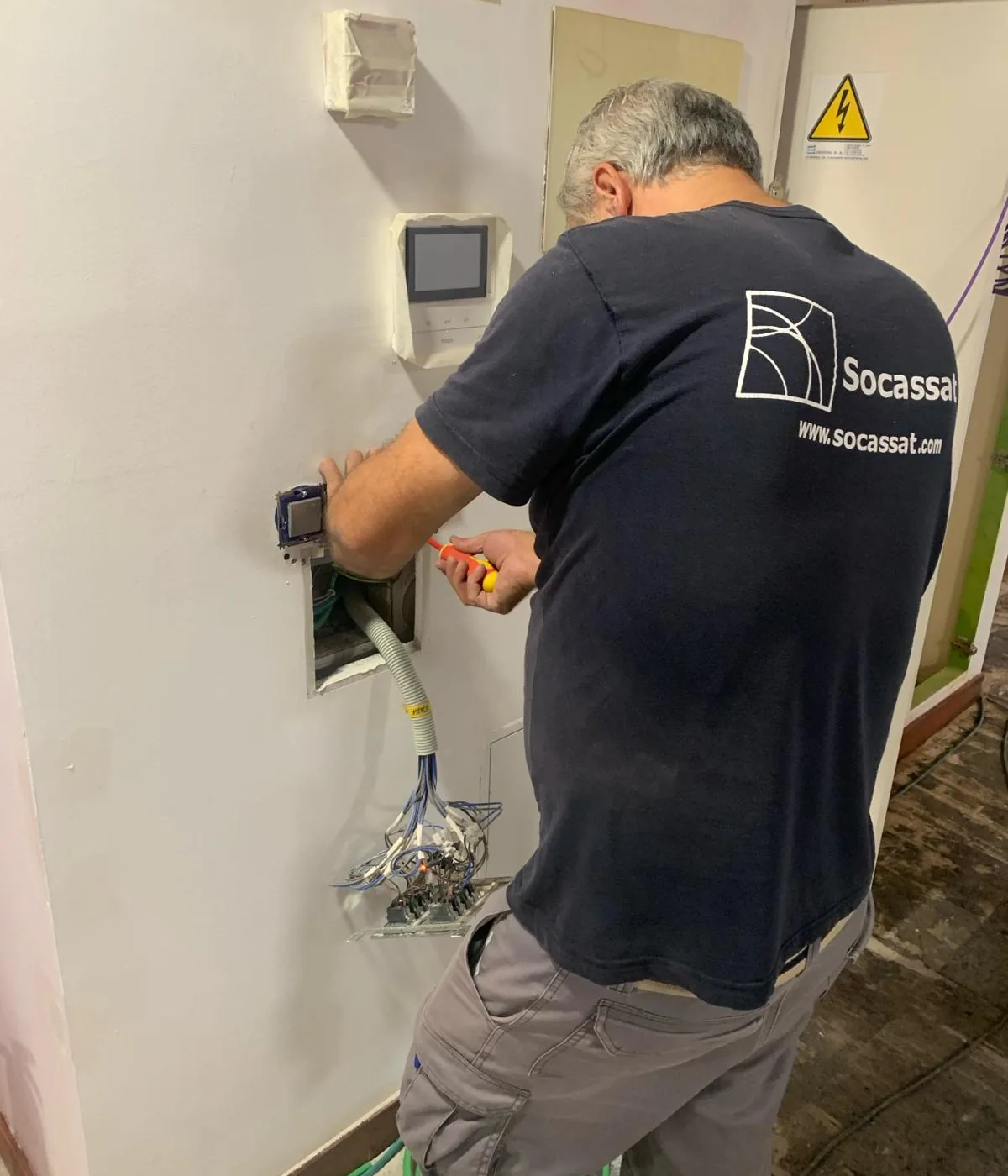 Electricista de Socassat conectando los mecanismos durante la reforma eléctrica de un local
