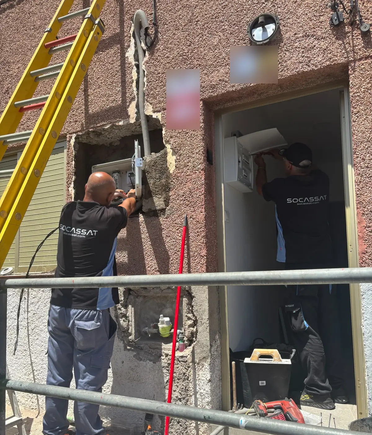 Técnicos de Socassat renovando la caja de protección y medida de la fachada y el cuadro eléctrico de la entrada de una vivienda