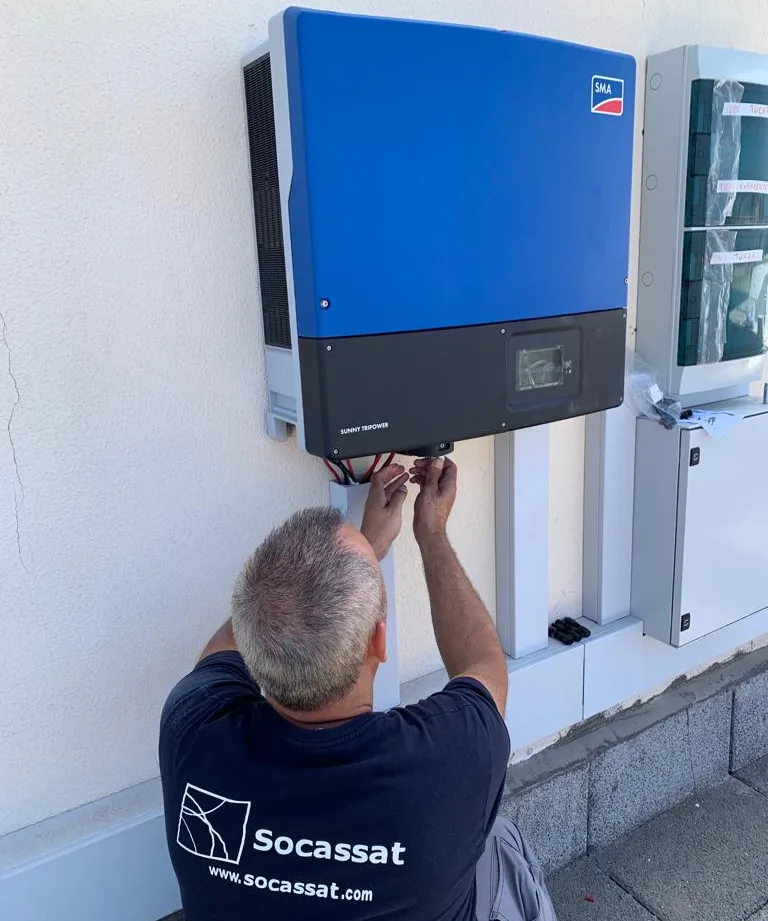 Técnico de Socassat conectando un inversor fotovoltaico trifásico instalado en la pared
