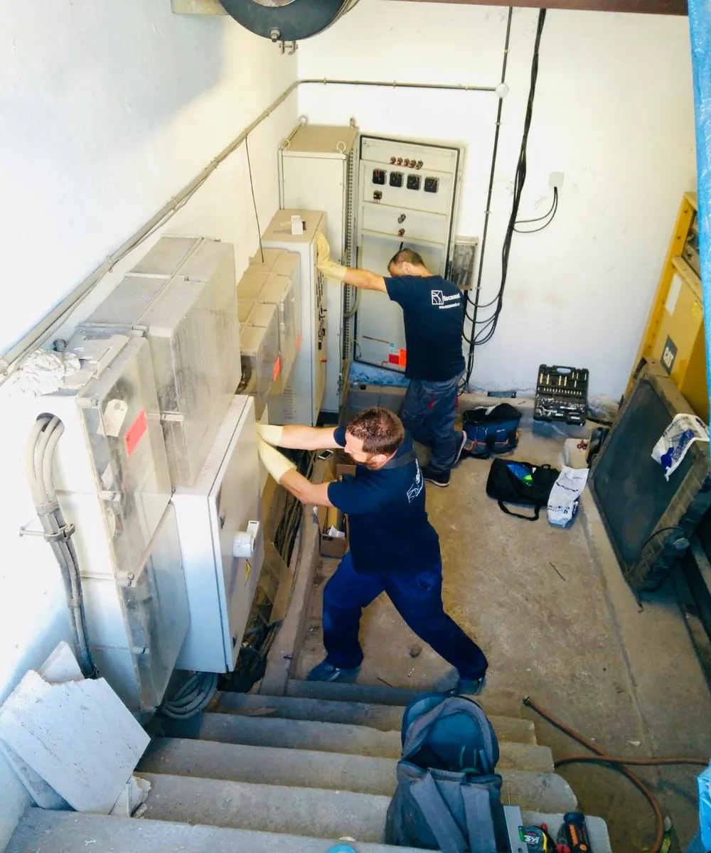 Técnicos de Socassat revisando los cuadros eléctricos de una sala técnica durante el mantenimiento de las instalaciones de una empresa