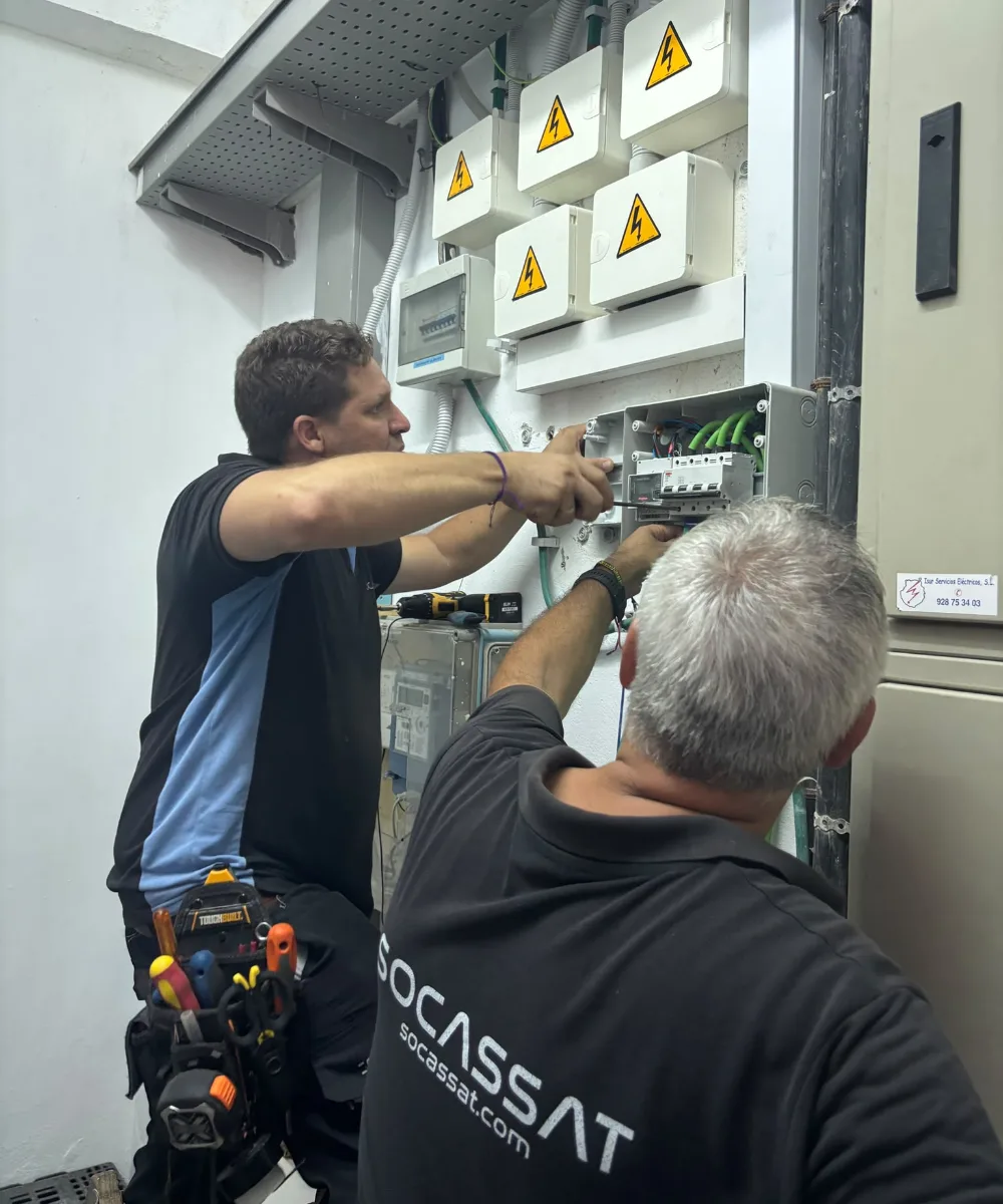 Dos técnicos de Socassat trabajando en la centralización de contadores de un edificio