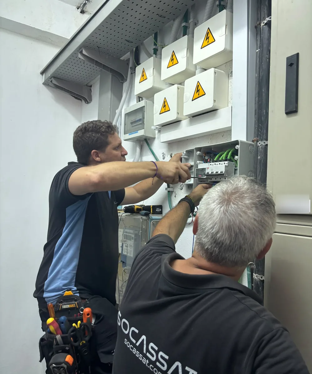Dos técnicos de Socassat trabajando en las protecciones del cuarto de contadores de un edificio