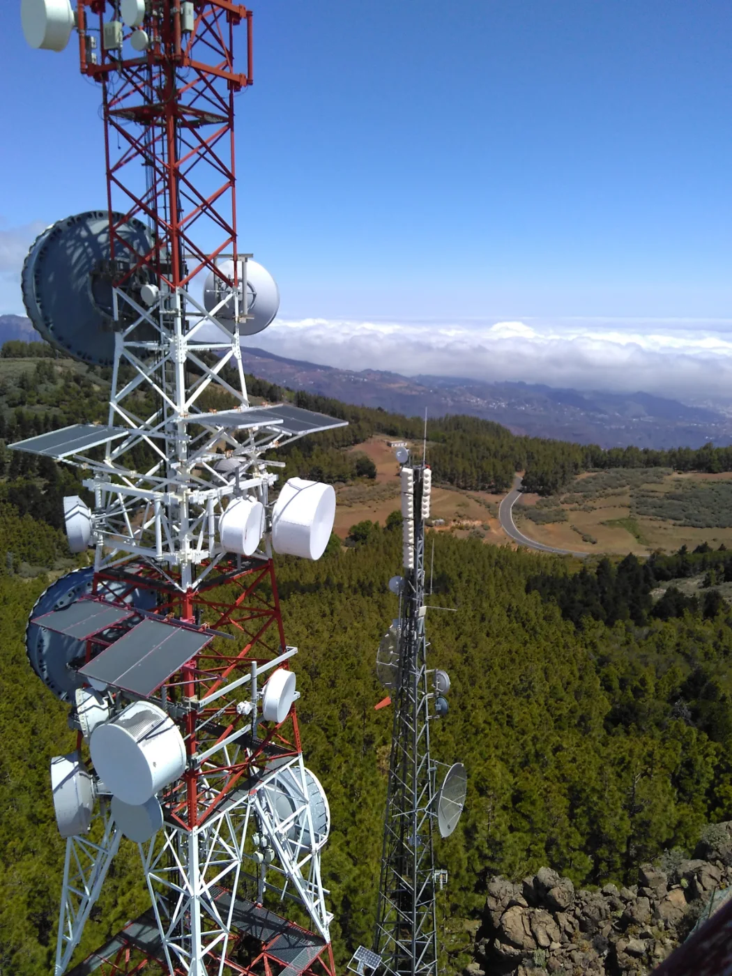 Torre de telecomunicaciones con antenas de radioenlace sobre el pinar y el mar de nubes, en un trabajo de Socassat en Canarias