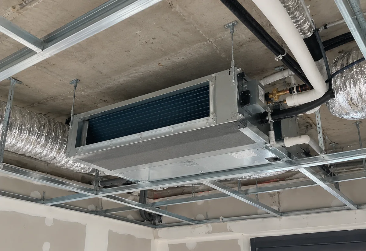 Unidad interior de aire acondicionado por conductos instalada en el falso techo antes de cerrarlo