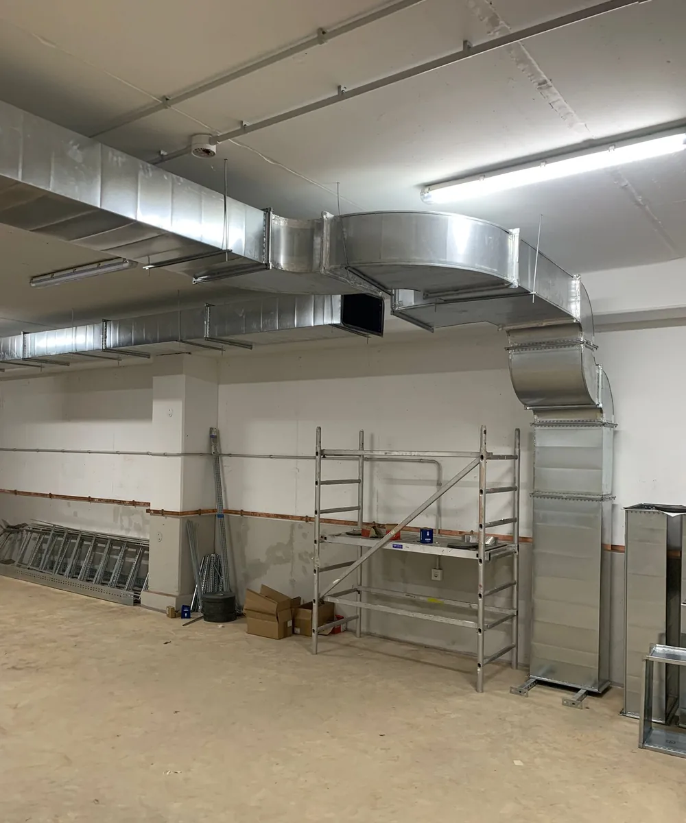 Conductos de ventilación de chapa galvanizada instalados en el techo de un garaje