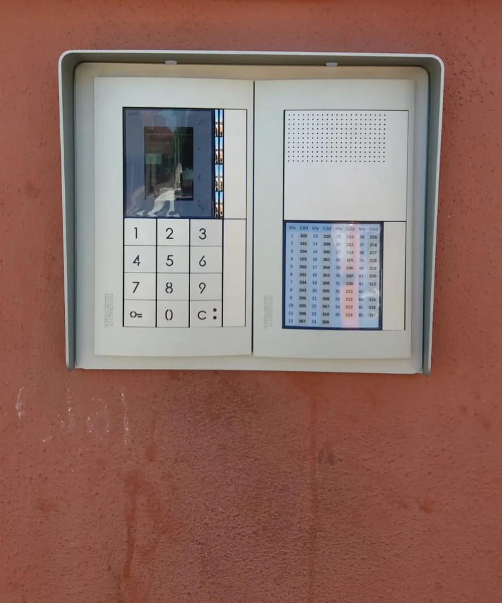Placa de videoportero Tegui con monitor de llamada y teclado codificado en la entrada de un edificio de oficinas y viviendas