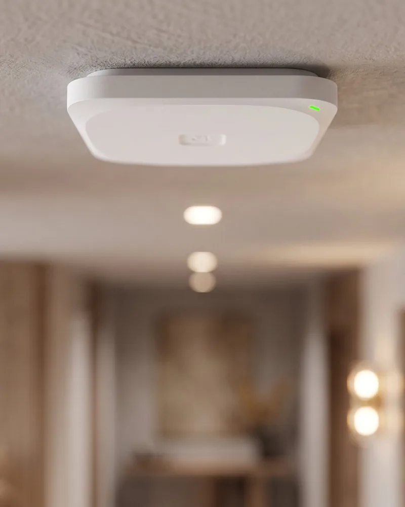 Punto de acceso WiFi de techo en el pasillo de una oficina, alimentado por PoE
