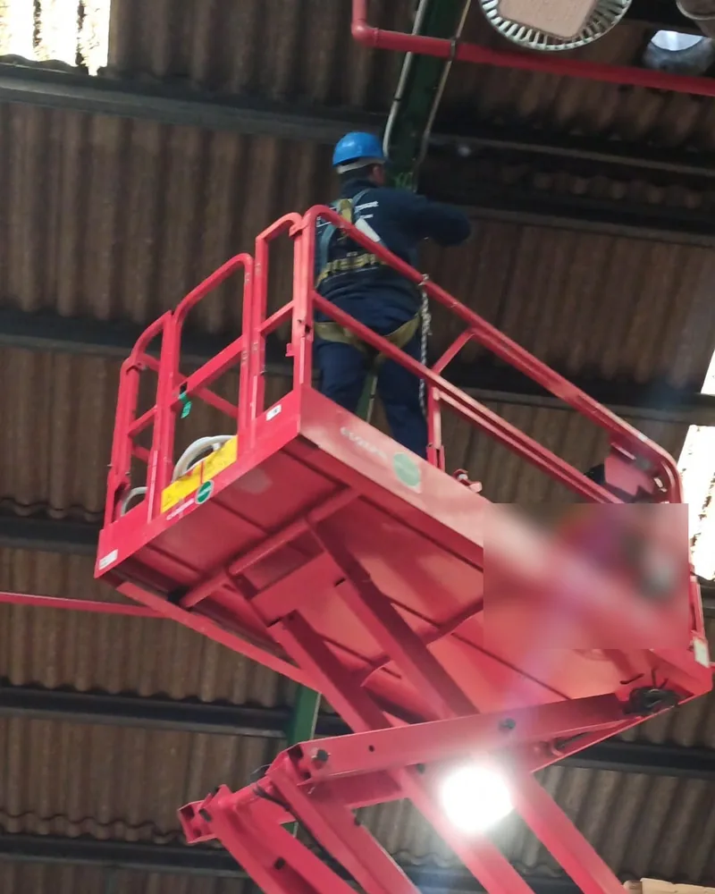 Técnico de Socassat instalando un punto de acceso desde una plataforma elevadora en la cubierta de una nave logística