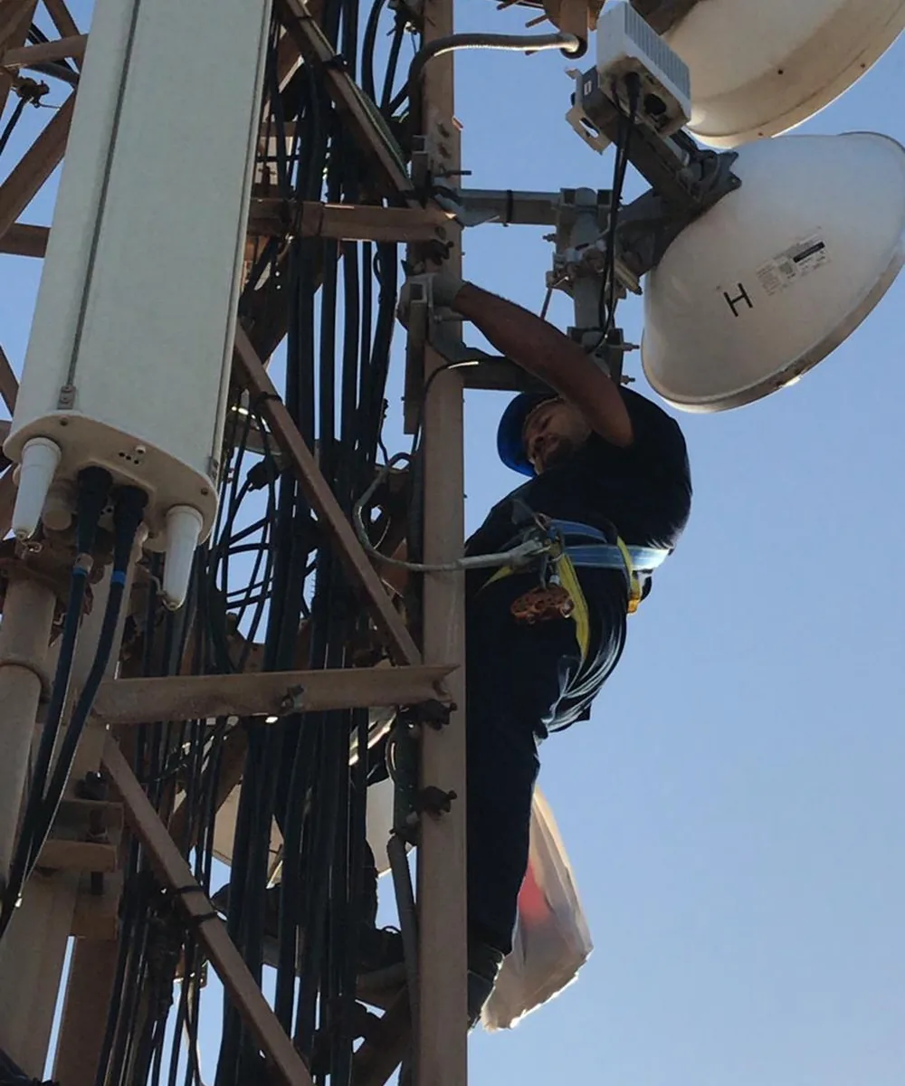 Técnico de Socassat alineando antenas de radioenlace punto a punto en una torre de comunicaciones